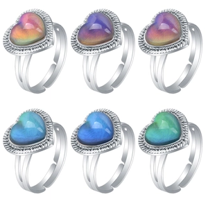 Set of six adjustable silver rings with heart-shaped color-changing stones on white back