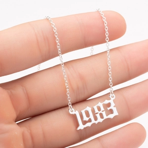 Close-up of a silver stainless steel birth year necklace featuring the numeric pendant 1983