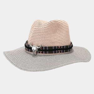 Detail of two-tone straw Panama hat with geometric band and silver bull head ornament