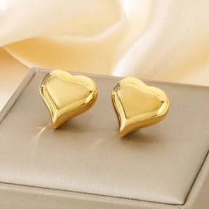 Polished 18k gold heart stud earrings in stainless steel on a luxury jewelry box