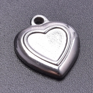 Close-up of polished silver heart pendant with ring connector for DIY jewelry making