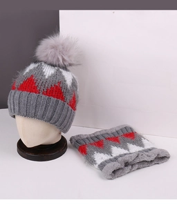 Detailed close-up of winter knit beanie with faux fur pom and matching fleece-lined neck warmer