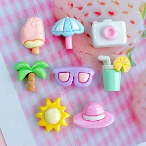 Close-up of 8 colorful resin summer beach accessories like palm trees and sunglasses