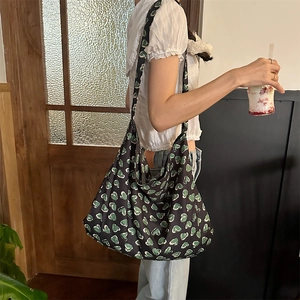 Detailed view of the large capacity floral shoulder bag worn by a model in a retro setting