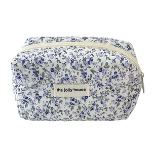 Floral quilted toiletry bag with blue and purple patterns and zip closure on white background