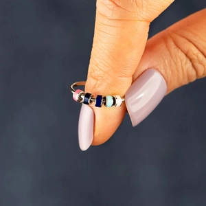 Macro shot of s925 silver spinning beads ring with pink and blue enamel for stress relief