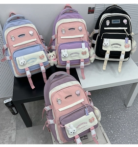 Various colors of nylon campus backpacks featuring cute plush charms and embroidery