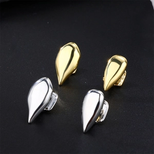 Detailed view of gold and silver plated hip hop fang grillz with cubic zirconia inlays