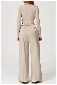 Rear view of sleek yoga long sleeve top and high waist wide leg pants set in beige