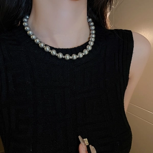 Detailed close-up of dark grey pearl choker necklace with silver spacer beads on model