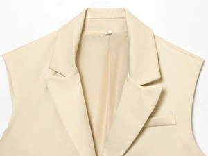 Détail du gilet beige à revers montrant la texture en sergé et les coutures de qualité