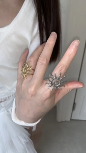 Macro detail of sunburst open rings in gold and silver finish with textured spiral centers