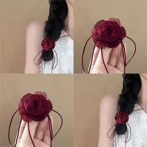 Vintage burgundy lace rose hair tie with elegant long ribbons on dark braided hair