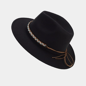 Détail d'un chapeau fedora noir en laine avec un ruban tressé ethnique et des perles turquoise