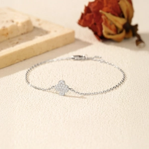 S925 sterling silver club clover bracelet with D color moissanite on textured background