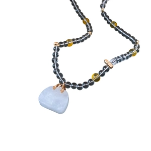 Elegant beaded necklace with grey beads and a white handbag-shaped jade pendant