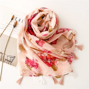 Detail of pink floral scarf with elegant cotton-linen texture and fringe tassels