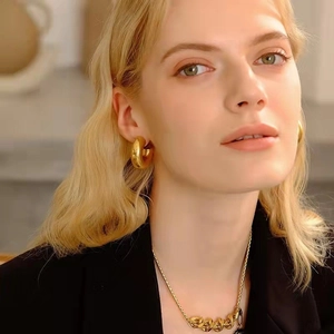 Minimalist chunky golden hoop earrings and thick chain necklace with high metallic luster