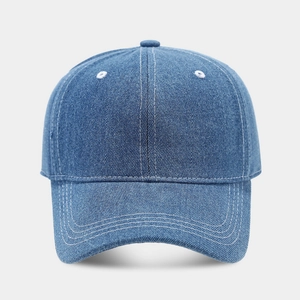 Detail of blue denim baseball cap featuring white contrast stitching and six-panel crown