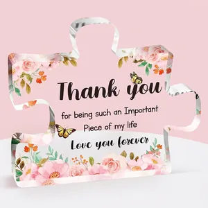 Detail of puzzle-shaped acrylic plaque with floral prints and Thank You message