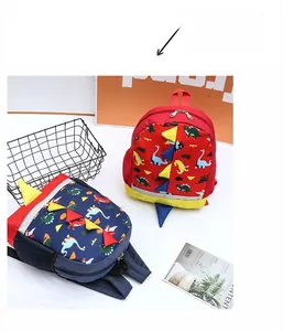 Detail of red and dark blue cartoon dinosaur backpacks with 3D decorative spines