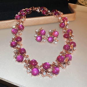 Macro view of rose gold jewelry set with purple gemstones and sparkling crystals