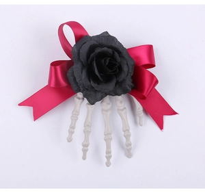 Gothic skeletal hand hair clip featuring a black fabric rose and dark red ribbon bow