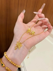 Detail view of a gold-plated palm tree necklace and earring set on a female model