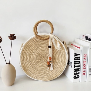 Minimalist round straw handbag with white lace ribbons and wooden bead tassel details