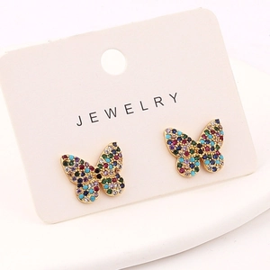 Close-up of golden butterfly earrings with colorful zircon stones on jewelry card