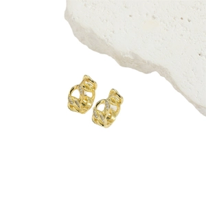 Minimalist gold Cuban chain earrings with white zircon inlays on white stone background