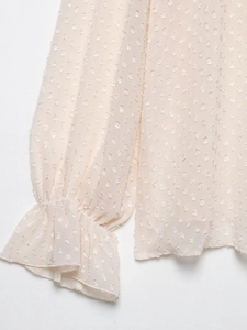Detail showing ruffle cuffs and 3D polka dot texture on elegant chiffon blouse