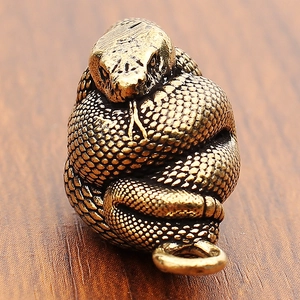 Dettaglio macro del ciondolo serpente in ottone antico con squame molto rifinite