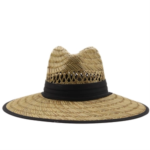 Dettaglio cappello di paglia a tesa larga con nastro nero e trama naturale