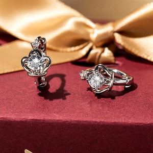 Elegant silver crown earrings with cubic zirconia set on a luxury red textured base