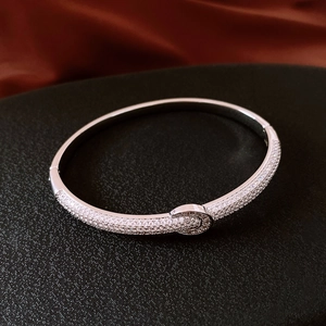 Macro shot of silver plated round clasp bangle with micro-paved cubic zirconia stones