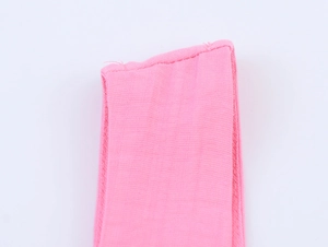 Detailed close-up of pink cotton gauze fabric with reinforced stitching on the edge