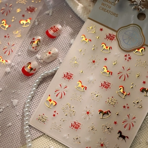 Detail of New Year nail stickers featuring gold rocking horse, fireworks, and star motifs