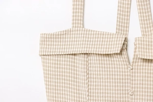 Close-up detail of khaki plaid halter dress showing fabric texture and sewing craftsmanship