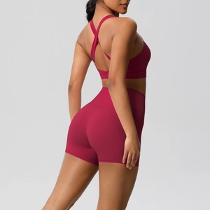 Detail of cross-back yoga bra and high-waisted lifting shorts in deep magenta set