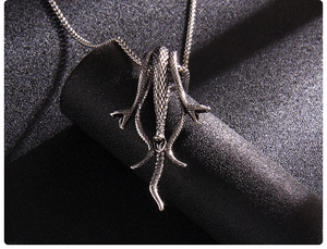 Gros plan d'un pendentif méduse en argent foncé avec des détails de peau de serpent