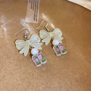 Detail of sweet bow earrings with resin square drop featuring pink roses and silver hooks