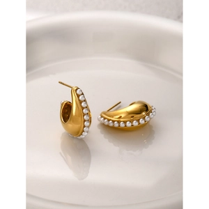 Detail of C-shaped 18k gold-plated earrings with pavé white pearls on ceramic