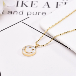 Collier en chaîne à billes dorées avec pendentif visage souriant en nacre blanche chic