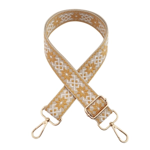 Macro detail of mustard yellow jacquard strap with golden rotating metal hooks