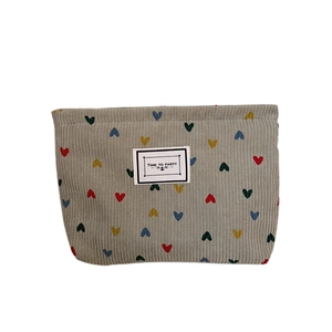 Corduroy travel cosmetic bag with colorful heart patterns and Time To Party label