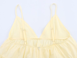 Detailed view of yellow embroidered camisole featuring delicate floral patterns and straps