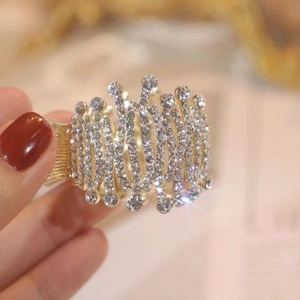 Detailed close-up of a golden ponytail clip set with sparkling rhinestones and wave patterns