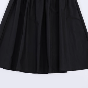 Détail d'une jupe midi noire élégante avec plis fins et couture d'ourlet de qualité