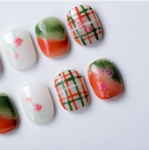 Close-up of 3D nail stickers featuring delicate rose patterns and orange-green plaid